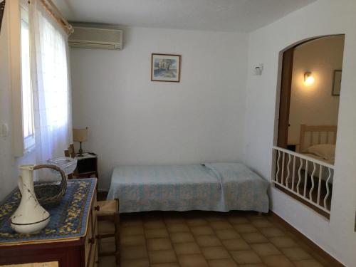 - une chambre avec un lit et un miroir dans l'établissement la pergola, à Cavalaire-sur-Mer