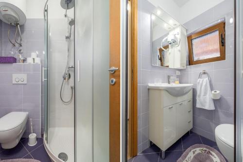 a bathroom with a shower and a toilet and a sink at Apartments Nono in Poreč