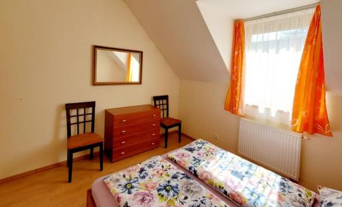 a bedroom with a bed and a dresser and a window at Apartment Highland in Stará Lesná