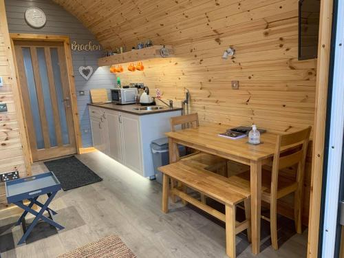 a wooden kitchen with a wooden table and a counter at Daviot Luxury Pods in Inverness