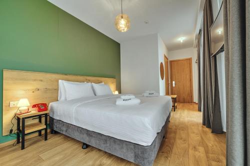 a bedroom with a large white bed and a table at Intourist Kazbegi in Stepantsminda
