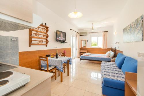 a living room with a blue couch and a table at SCALA APARTS & STUDIOS - Rhodes in Afantou