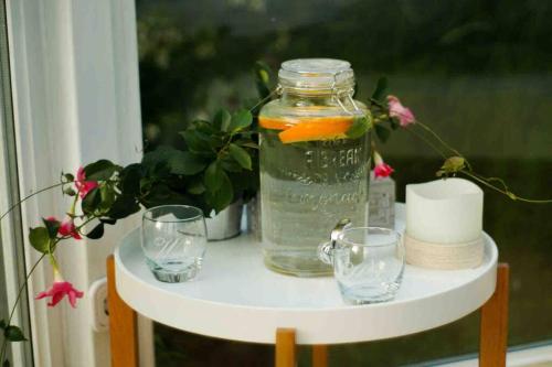 a jar of water and two glasses on a table at Glashaus Sternblick, Schlafen unterm Sternenhimmel in Neustadt am Kulm