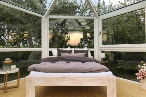 a bedroom with a bed in front of a window at Glashaus Sternblick, Schlafen unterm Sternenhimmel in Neustadt am Kulm