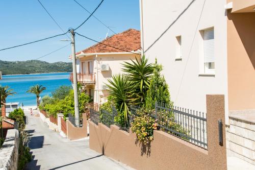 a house with a balcony with a view of the ocean at Apartments Ploka in Trogir