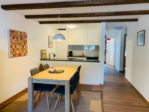 a kitchen and dining room with a wooden table and chairs at Appartements Elan in Zermatt