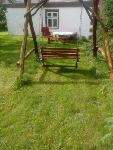 a swing in a yard with a table at Pokoje u Roberta in Węgorzewo