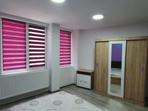 a room with two windows with pink blinds at Apartament negris in Bîrlad