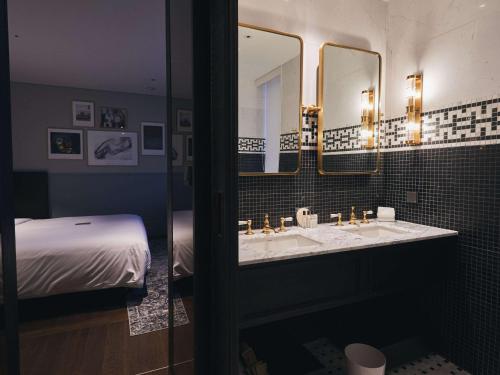 a bathroom with two sinks and two mirrors at Hotel Crescendo Seoul in Seoul