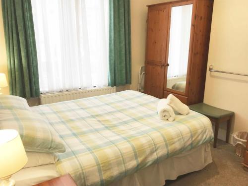 a bedroom with a bed with two stuffed animals on it at Esk Vale Guest House in Portsmouth