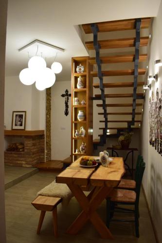 a dining room with a wooden table and stairs at U Stařenky in Dolní Bojanovice