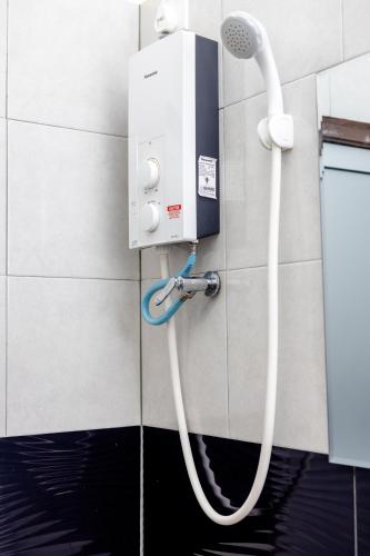 a shower in a bathroom with a hose at Cenang Rooms With Pool by Virgo Star Resort in Pantai Cenang