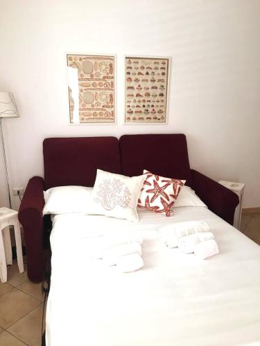 a white bed with pillows on it in a room at Almarea Corallo - villa a 300m dalla spiaggia con parcheggio - Polignano a Mare in Polignano a Mare