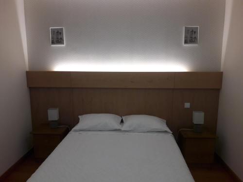 - un lit avec 2 oreillers et un éclairage au-dessus dans l'établissement Casa Ribom, à Gerês