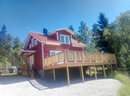 a large red house with a large deck at Dimgården in Leksand