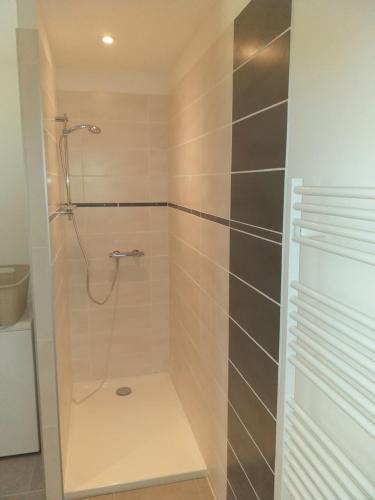 une douche avec une porte vitrée dans une salle de bain dans l'établissement Maison de vacances, à Laurac-en-Vivarais