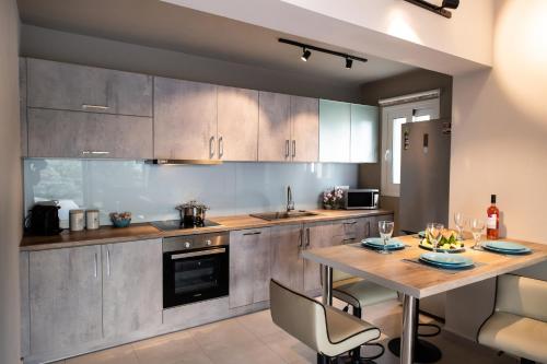 a kitchen with a wooden table with chairs and a dining room at ANATOLI VILLAS in Nikiana