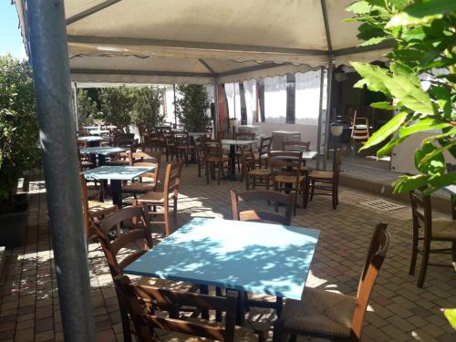 a patio area with tables, chairs and umbrellas at Koko Hotel in Milano Marittima