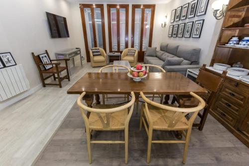 una cucina e un soggiorno con tavolo e sedie in legno di Espacioso Apartamento a estrenar!! Casco Viejo a Bilbao