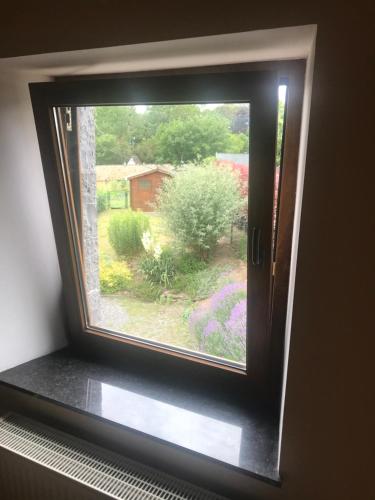 a window in a room with a view of a garden at En mode Pause in Dinant