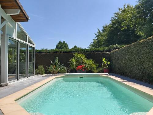 a swimming pool in the backyard of a house at Le Soleil Couchant in Angresse