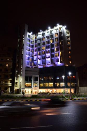 a large building with blue lights on it at night at Romance Alexandria Hotel in Alexandria