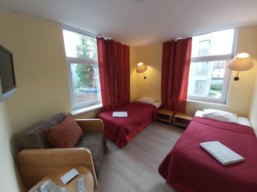 um quarto de hotel com duas camas e um sofá em Viva Nord Hotel em Talin