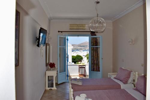 una camera con letto e porta di accesso a un balcone di Minoa Hotel a Naoussa