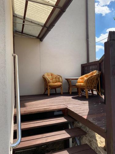 a porch with two chairs and a table on it at Mazury Apartament in Ostróda