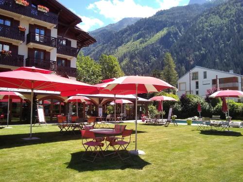 a group of tables and chairs with red umbrellas at Oustalet in Chamonix
