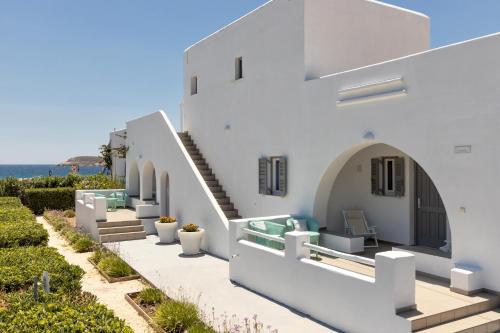 a white house with stairs and a view of the ocean at Golden Beach Hotel in Chrissi Akti