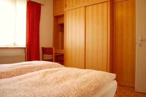 1 dormitorio con cama y cortina roja en Skilifts & Central | Palma A en Crans-Montana