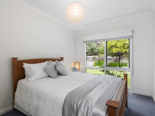 - une chambre blanche avec un grand lit et une fenêtre dans l'établissement Niche On Noble, à Anglesea
