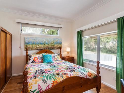 a bedroom with a bed and two windows at Ocean Sounds in Anglesea