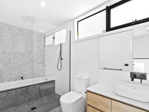 a bathroom with a toilet and a sink and a shower at Point Break in Anglesea