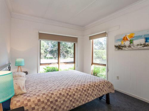 a bedroom with a bed and a large window at Oceans 12 in Anglesea