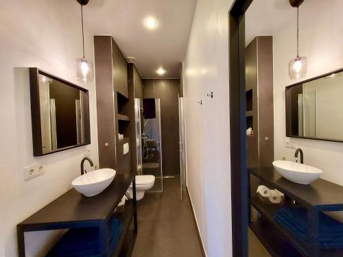 a bathroom with two sinks and two mirrors at Ferienwohnung Regattastrecke Berlin in Berlin