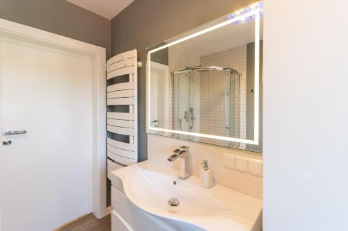 a bathroom with a sink and a large mirror at Marina in Międzyzdroje