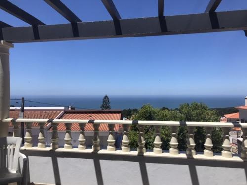 a white railing on a balcony with the ocean in the background at Vivenda Azevedo in Nazaré