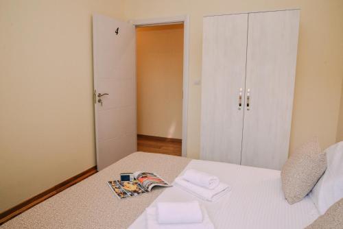 a bedroom with a white bed and a closet at Step to Kotor bay Guesthouse in Kotor