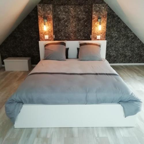 une chambre avec un grand lit blanc avec deux oreillers dans l'établissement La Petite Pause, à Verlinghem