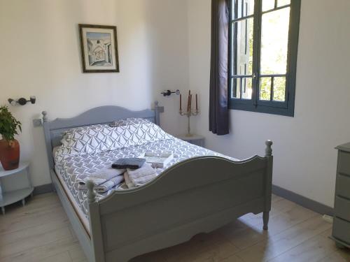 um pequeno quarto com uma cama e uma janela em Auberge du Chêne em Maureillas