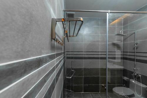 uma casa de banho com um chuveiro e uma porta de vidro em Fusionsea Villa em Vung Tau