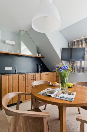 a dining room with a wooden table and chairs at Palanga Visit Apartments and SPA in Palanga