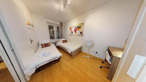 Habitación pequeña con 2 camas y ventilador. en 70 m² Strasbourg Appart city center, en Estrasburgo