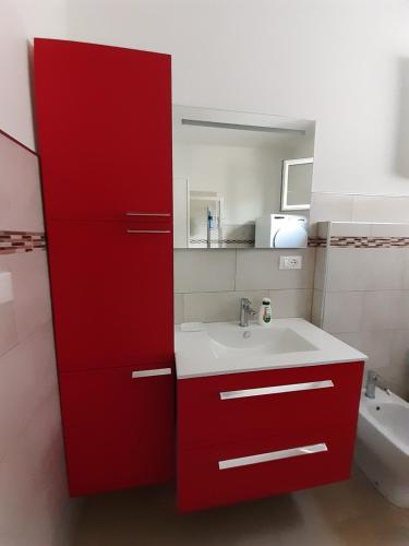 uma casa de banho com um armário vermelho e um lavatório em CASA CONTE em Pordenone
