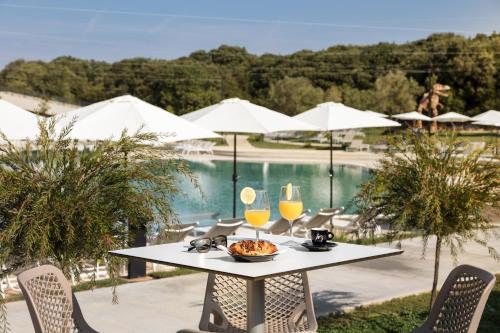 a table with a bowl of food and two glasses of orange juice at Design Villa Noble with Spa in Bale