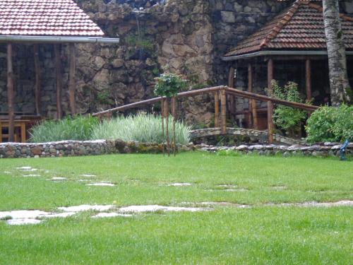 a garden with a stone building and a wooden bridge at Eco Garden Dilijan in Dilijan