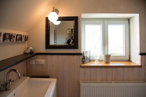 La salle de bains est pourvue d'un lavabo, d'un miroir et d'une fenêtre. dans l'établissement Gästehaus Kohlberg, à Kohlberg