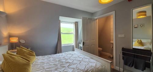 a bedroom with a bed and a door with a window at Rocky Cove Bed and Breakfast in Ilfracombe